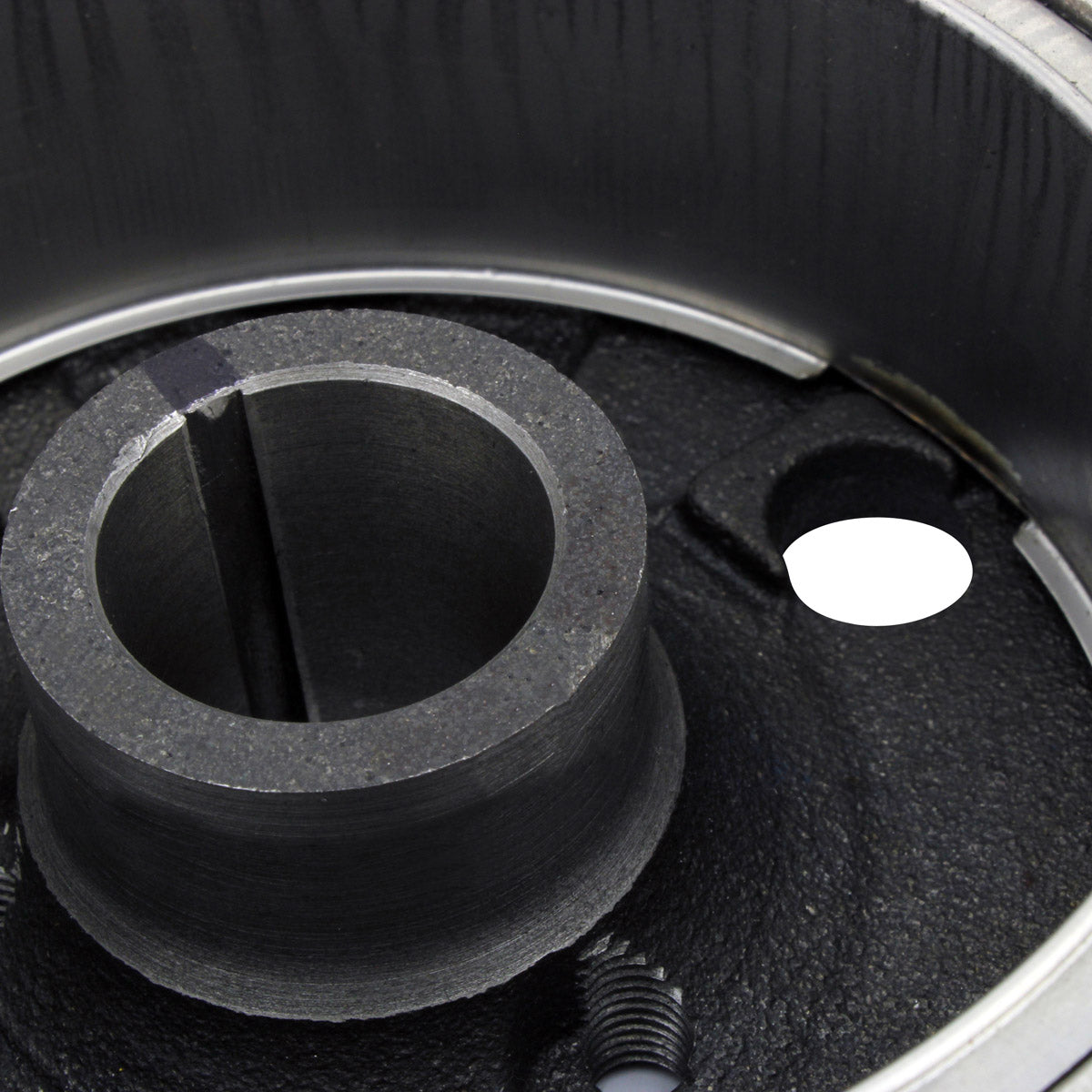 Black round flywheel component with central cylindrical hub and metal outer ring for motorcycle engine.