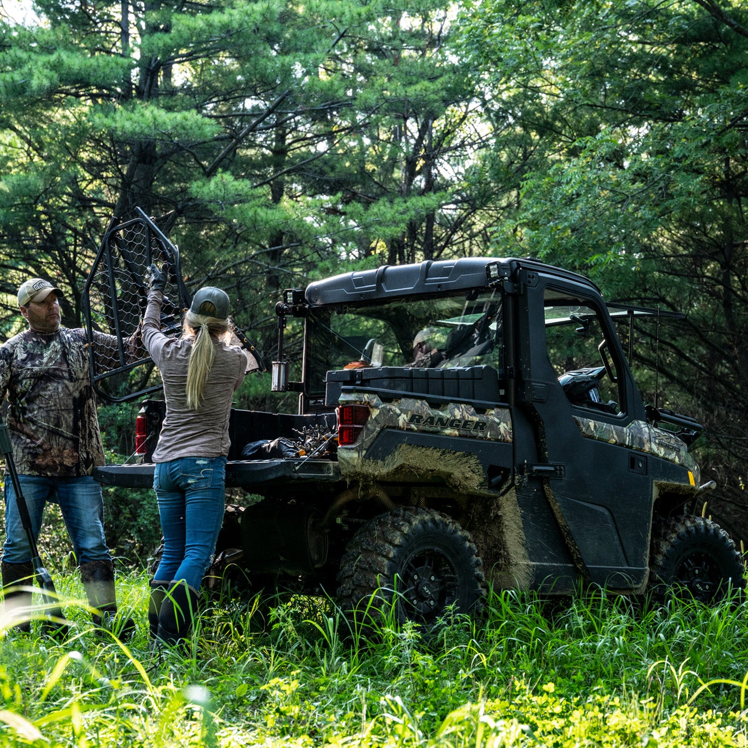 Tinted rear glass panel with Lock & Ride mounting system installed on a black Polaris Ranger UTV in a forest setting.